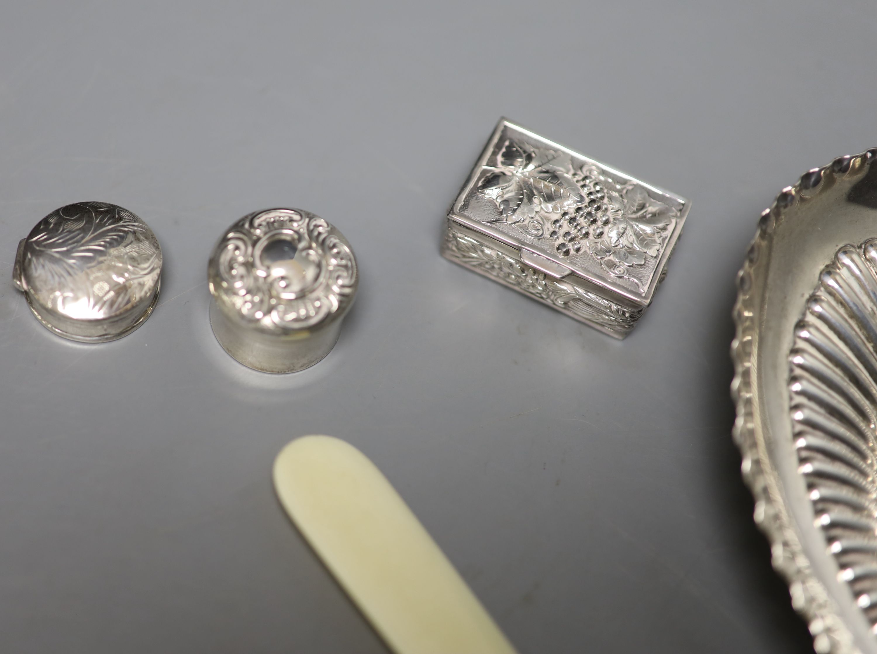 A late Victorian demi-fluted oval dish, London, 1897, 15.2cm, a silver handled paper knife & 5 boxers.
